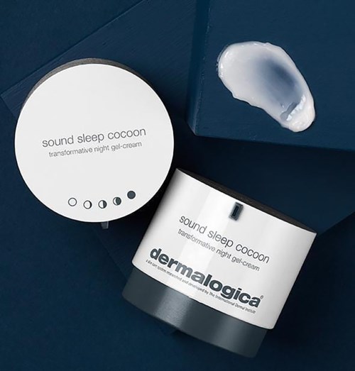 En hvit krukke og et folie lokk fra Dermalogica sovgel. Krukken viser produktnavn og merke. Folielokket er åpent.