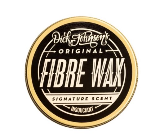 Een ronde logo met zwarte, witte en gouden kleuren, toont merknaam en geurbeschrijving voor fiberwas.