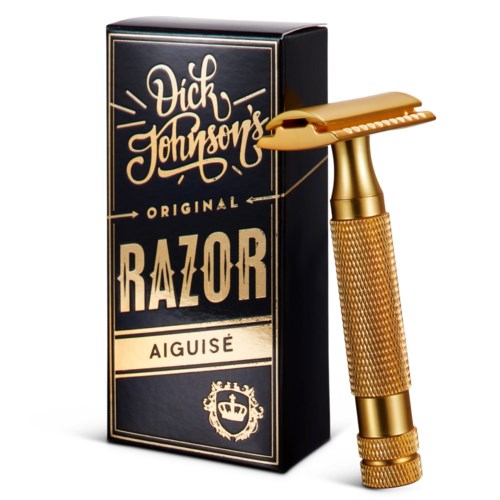 Kultaisen värinen turvallisuus partaterä ja musta laatikko, jossa on kultaisia ja valkoisia tekstejä. Laatikossa lukee "Vik Johnson's Original Razor Aiguisé."