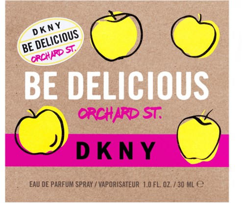 En DKNY parfymetikett med gula äpplen, rosa- och svarta detaljer och text om Orchard St. och doft.
