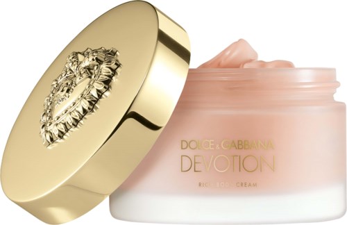 En krukke merket Dolce & Gabbana Devotion Rich Body Cream med et gull lokk med en løve-emblem.