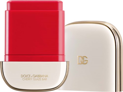 En rød leppestiftbeholder med en gull- og hvit eske ved siden av, merket Dolce and Gabbana cherry glaze bar.