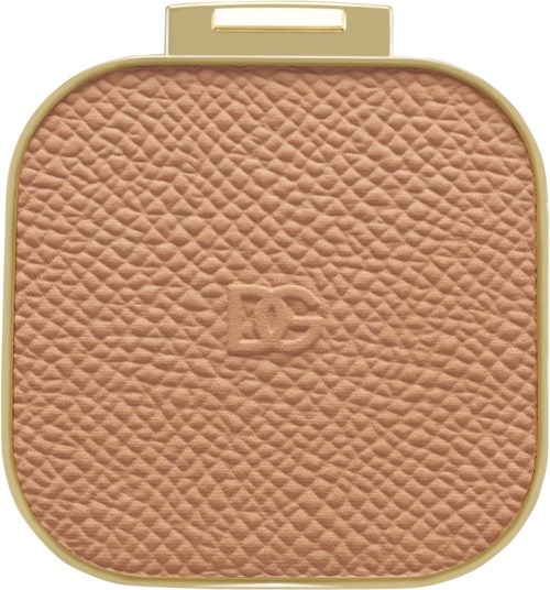 Komprimeret pudder med tekstureret beige overflade og guldæske.