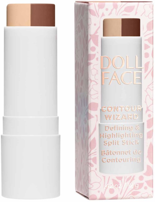 Korektor w sztyfcie w odcieniach beżu i ciemniejszym, obok różowo-białego opakowania z kwiatowym wzorem. Etykiety: 'Doll Face' i 'Contour Wizard.'