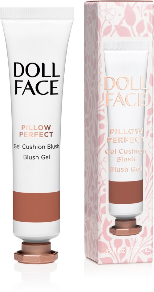En hvit tube og en rosa eske inneholder Doll Face Pillow Perfect gelrouge. Tuben har svart og rosa tekst, esken har blomsterdesign.