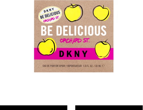 Bildens etikett har gula äpplen, rosa, vitt och beige färger, och text som marknadsför doften 'Be Delicious'.