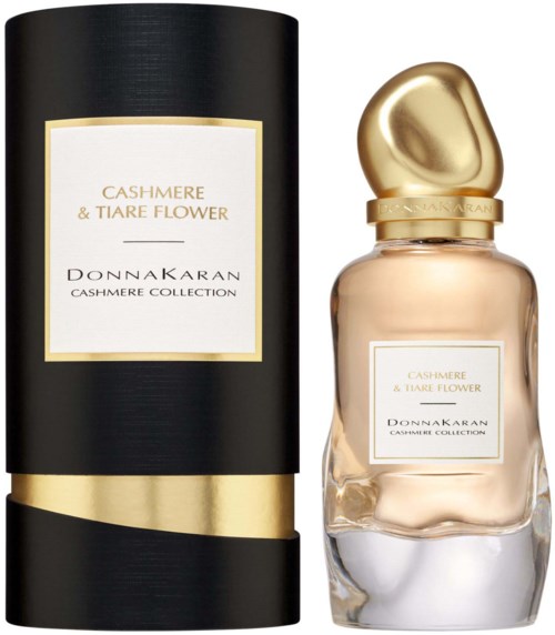 A perfume bottle with a gold cap and a black box packaging, both labeled 'Cashmere & Tiare Flower' from Donnakaran.