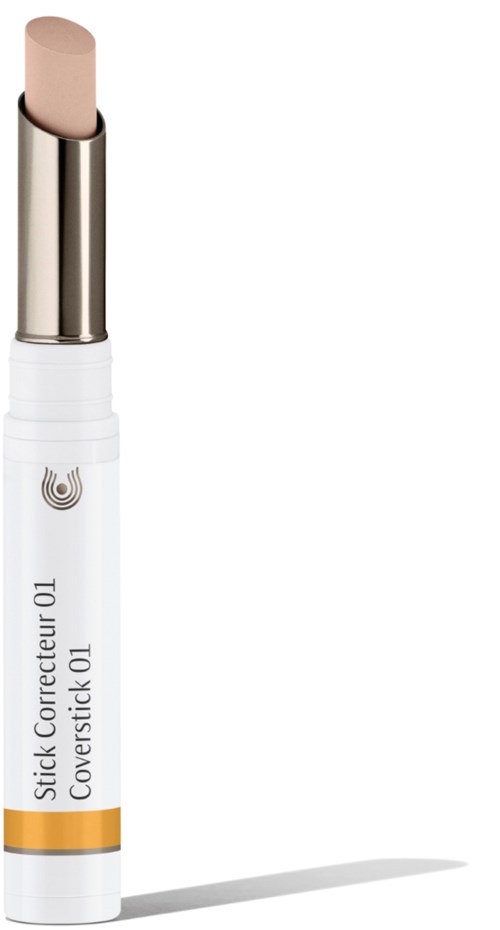 Ett vitt läppstiftsliknande stift med beige topp och gul band, märkt "Stick Correcteur OL Coverstick OL."