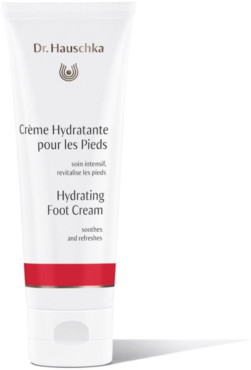 En vit tub med fotkräm med röda och gråaccenter, märkt som Dr. Hauschka Hydrating Foot Cream.