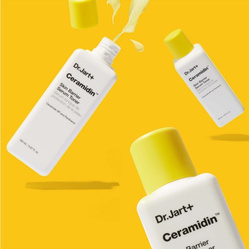 Three bottles of skincare products with yellow caps, labeled 'Dr. Jart+ Ceramidin'. One is open with cream escaping.