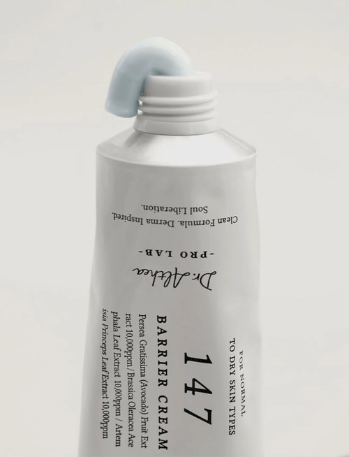 En vit tub med Dr. Jalcunde Barrier Cream med blå topp, som är vält och har lite kräm som visar.