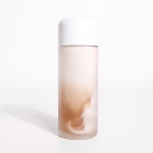 Eine lange, weiße und beige zylindrische Flasche mit rundem Deckel. Es sieht aus wie ein Hautpflege- oder Kosmetikprodukt.
