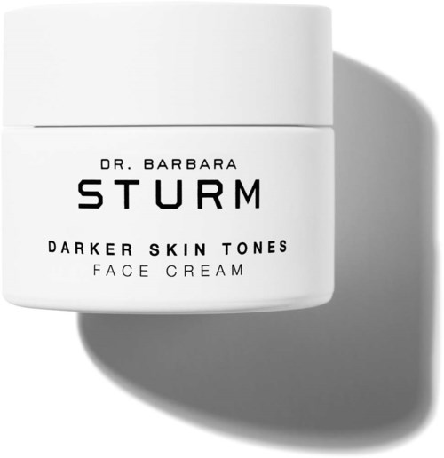 En vit burk med etiketten 'Dr. Barbara Sturm Darker Skin Tones Face Cream' och en skugga på högra sidan.