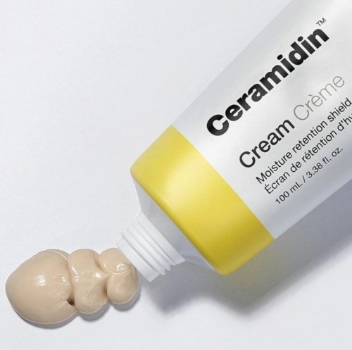 En tub märkt Ceramidin Cream med kräm som pressas ut nära öppningen.