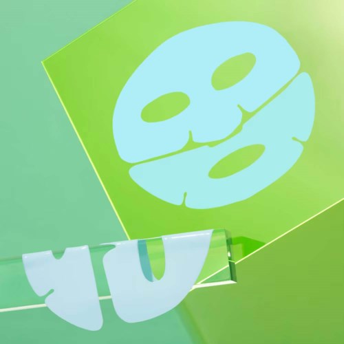 A green background with a white smiling face mask and fluffy towel hanging on a rod.