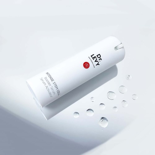 En vit hudvårdsflaska med silverlock, märkt Intensive Stem Cell Serum med droppar av serum runt den.