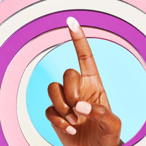 En hånd med rosa negler peker oppover, omgitt av fargede sirkulære mønstre i rosa, lilla og hvit.