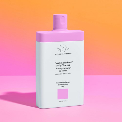 En vit kroppsvårdsflaska med rosa lock och etikett, med en logga, på en rosa och orange bakgrund.