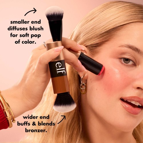 En kvinne påfører blush med en sminkbørste for et mykt, fargefullt utseende.