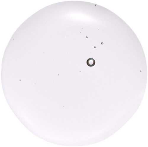 En klar, rund vätskedropp med små bubblor inuti på vit bakgrund.