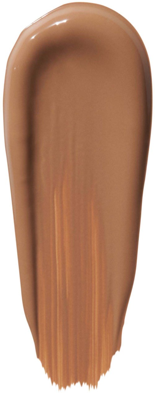 Ett färgprov visar ljusbrun makeup eller foundation med en krämig textur på en vit bakgrund.