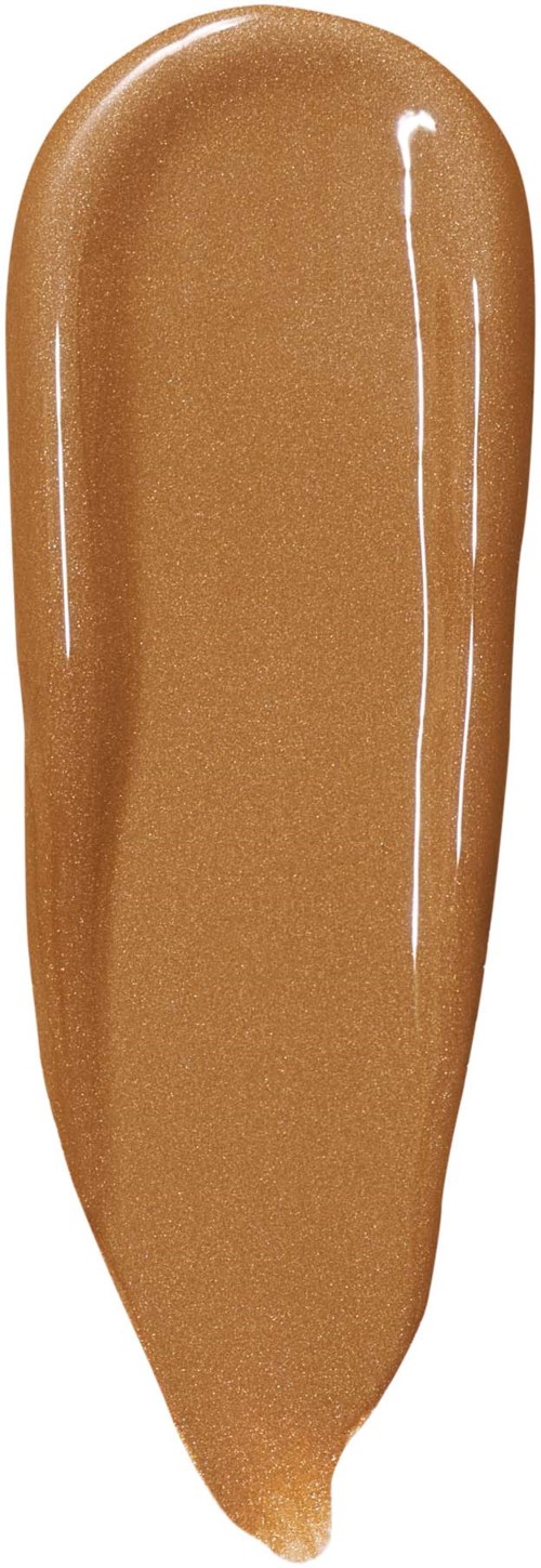 En provbit av glansig, beigeaktig makeupgrund eller concealer med en slät textur.