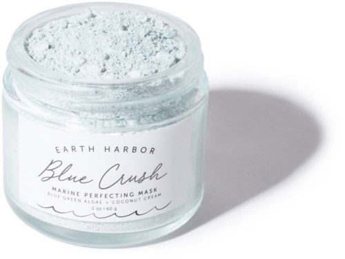 En burk med Blue Crush ansiktsmask med vitt pulver inuti, etiketten nämner Earth Harbor, havs- och kokosingredienser.