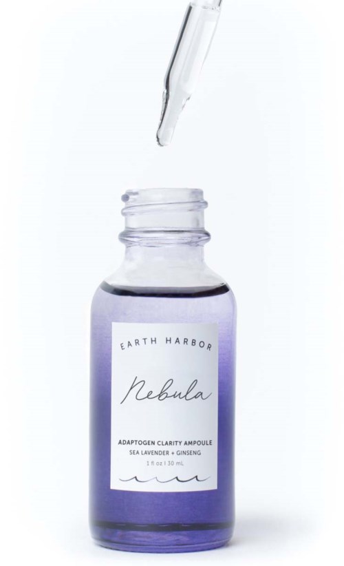 Een klein paarse fles met pipet, labeled 'Rebula' van Earth Harbor, met serum of essence.