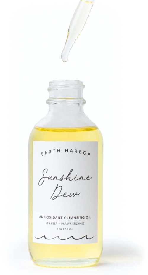Een doorzichtige fles met gele olie, labeled 'Sunshine Dew' met pipet erboven op een witte achtergrond.