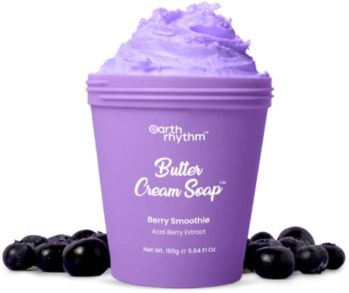 Fioletowy pojemnik z masłowym kremem mydłem o smaku smoothie jagodowego, otoczony borówkami.
