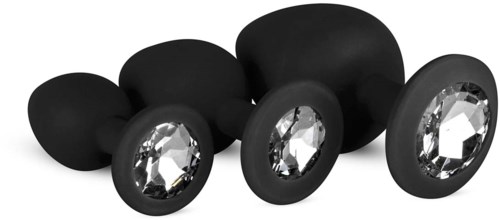 Four black earring stoppers with large clear gem-like decorations, arranged in size from small to large.