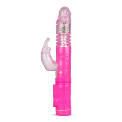 Ett rosa leksak med ett klart, kurvigt parti upptill och ett texturerat grepp. Den har små kulor inuti och en knapp nedan.