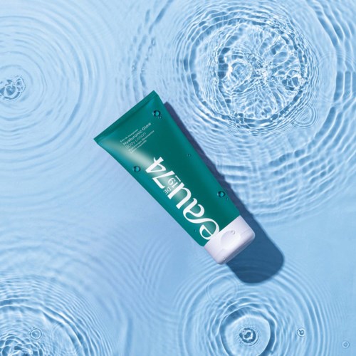 A tube of skincare cream floats in clear water, creating ripples around it.