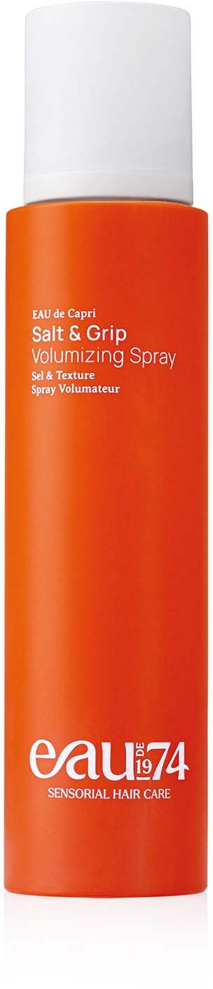 Orange spray bottle labeled 'Salt & Grip' for hair styling, with a white cap.