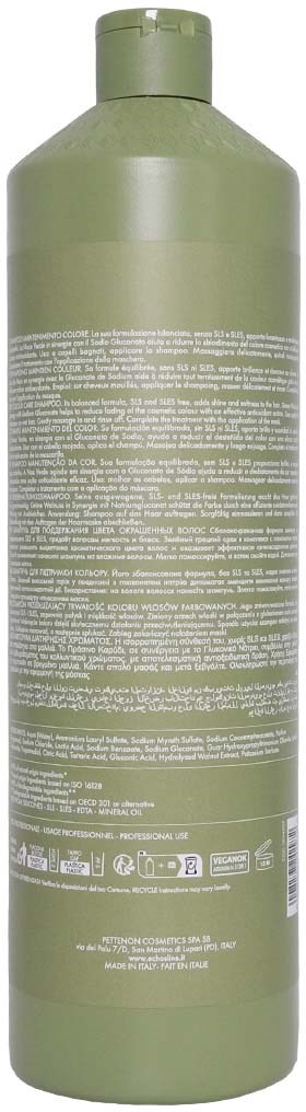 En lång, grön flaska med många vita textssträngar på, troligen en schampo- eller balsamflaska.