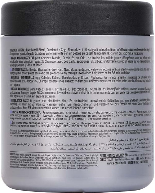 The image shows a white bottle with a black lid, likely a shampoo or hair product, with various language texts on it.