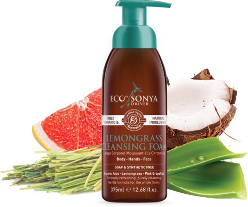 En brun flaske med renseskum og grønn pumpe, omgitt av sitron, grapefruit, kokosnøtt og aloe vera.