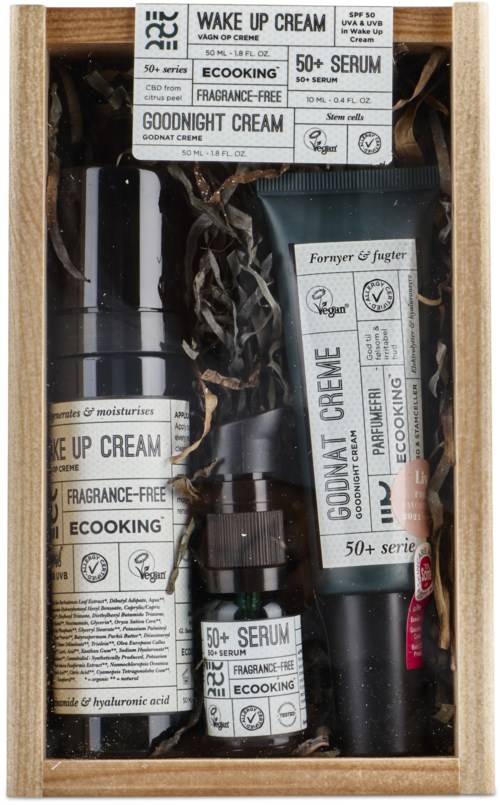 A gift set of skincare products including creams and serums with natural ingredients, in a wooden box.
