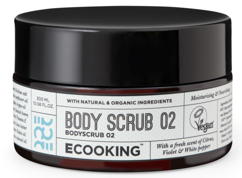En svart krukke merket 'BODY SCRUB 02' med naturlige økologiske ingredienser, vegansk symbol, sitrusduft, fiolett og hvit pepper.