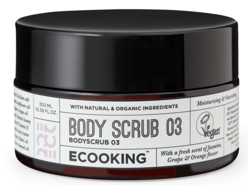 En svart krukke merket 'Body Scrub 03' med naturlige ingredienser, vegansk og med duft av jasmin og appelsin.