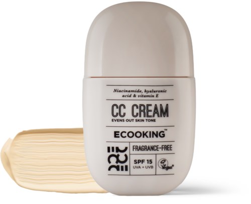 En hvid flaske CC-cream med lidt udstrakt på en overflade, mærket som SPF 15 og parfume-fri.
