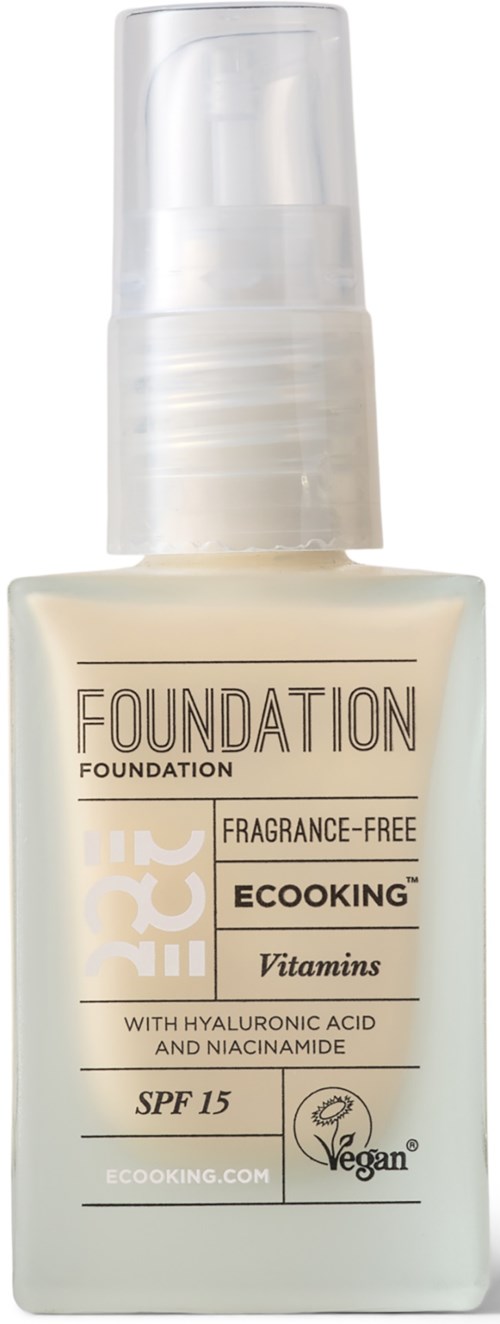 En hvid foundationflaske med spraypumpe, mærket med SPF 15 og vitaminer.