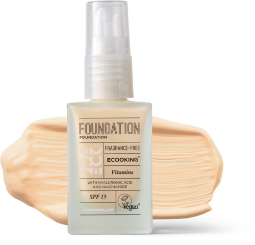 Flaske med flydende foundation i lys beige, med en smækelignende baggrund. Den er duftfri, vegansk og har solbeskyttelse SPF 15.