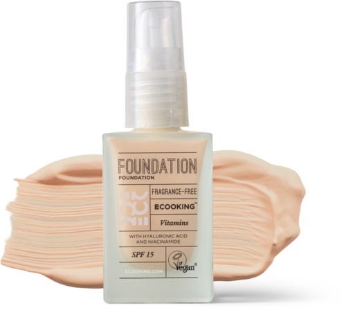 Flaske med duftfri foundation med SPF 15 og vitaminer, viser beige nuance bagved.
