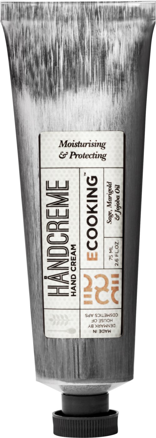 Et metalrør med mærkat til håndcreme, der er fugtgivende, beskyttende og miljøvenlig med orange og sort tekst.