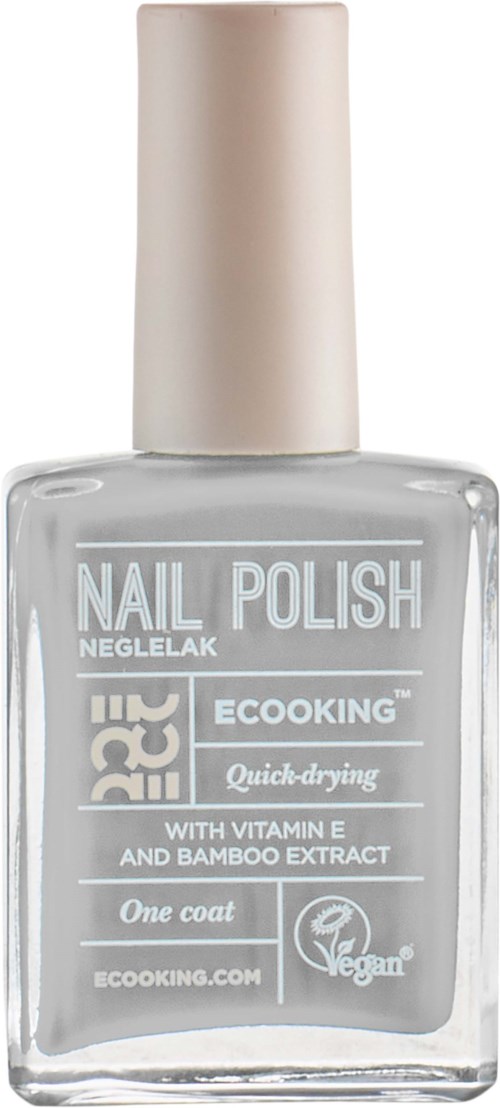 A clear glass bottle of nail polish with a beige cap. Label shows it is quick-drying with vitamin E and bamboo.