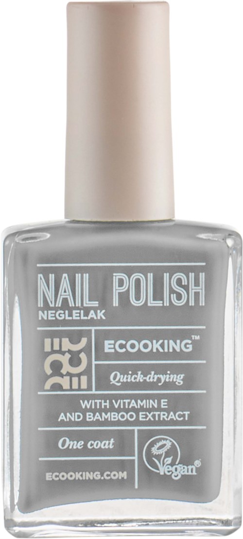 A clear nail polish bottle with a white cap, labeled as eco-friendly, quick-drying, with vitamin E and bamboo extract.
