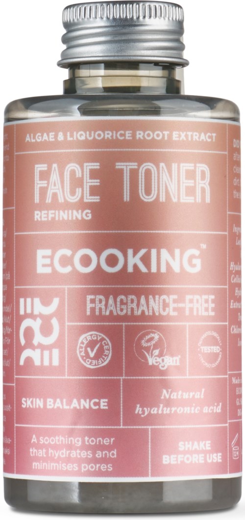 Lyserød flaske med ansigtsvandt med etiketter om naturlige ingredienser, vegansk, parfumefri og hudfordele.