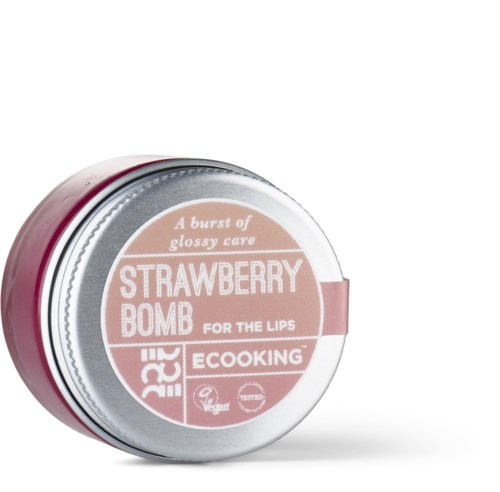 Różowy pojemnik z etykietą 'Strawberry Bomb for the Lips' i wzmianką o błyszczącej pielęgnacji oraz produkcie wegańskim.