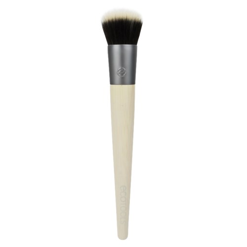 En makeupborste med trähandtag och täta borst, används för att applicera puder eller rouge.